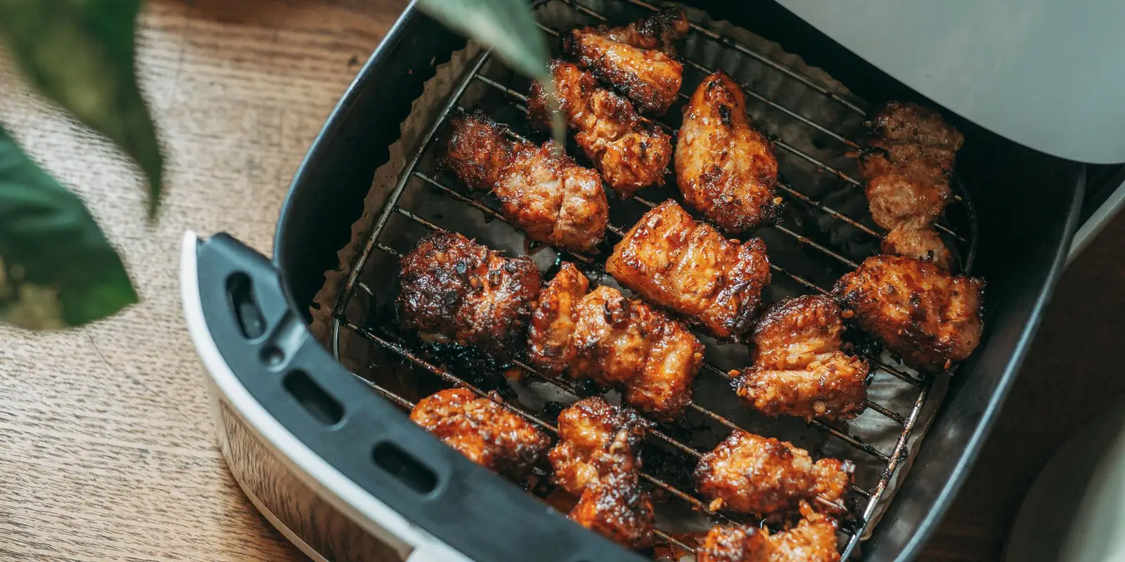 Crispy chicken pieces on the rack of an open air fryer drawer
